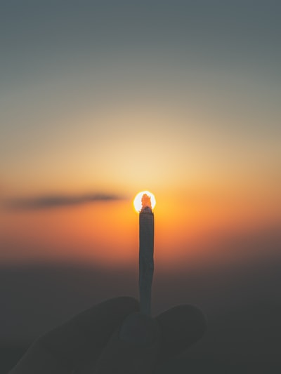 Holding a lighted cigarette stick
